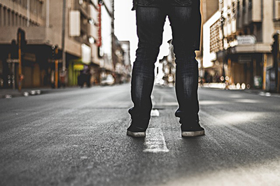 man's legs facing down a long street