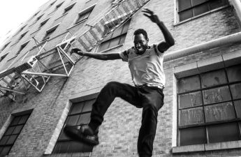 young man jumping off of a fire escape