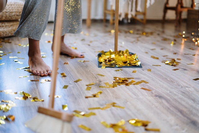 woman sweeping up gold confetti