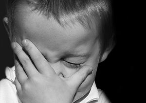 child covering face with hand