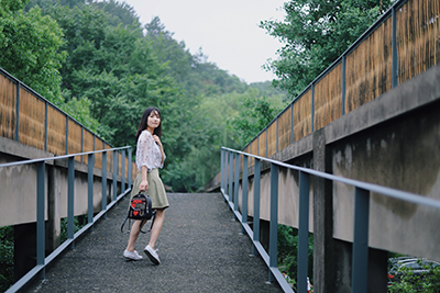 young woman holding a bag and looking back over her shoulder