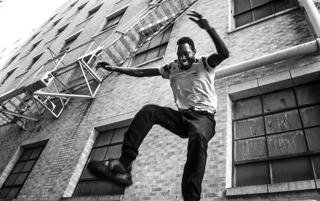 young man jumping off of a fire escape