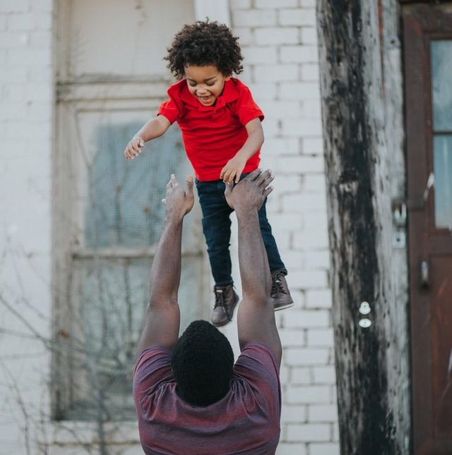 dad tossing boy in the air