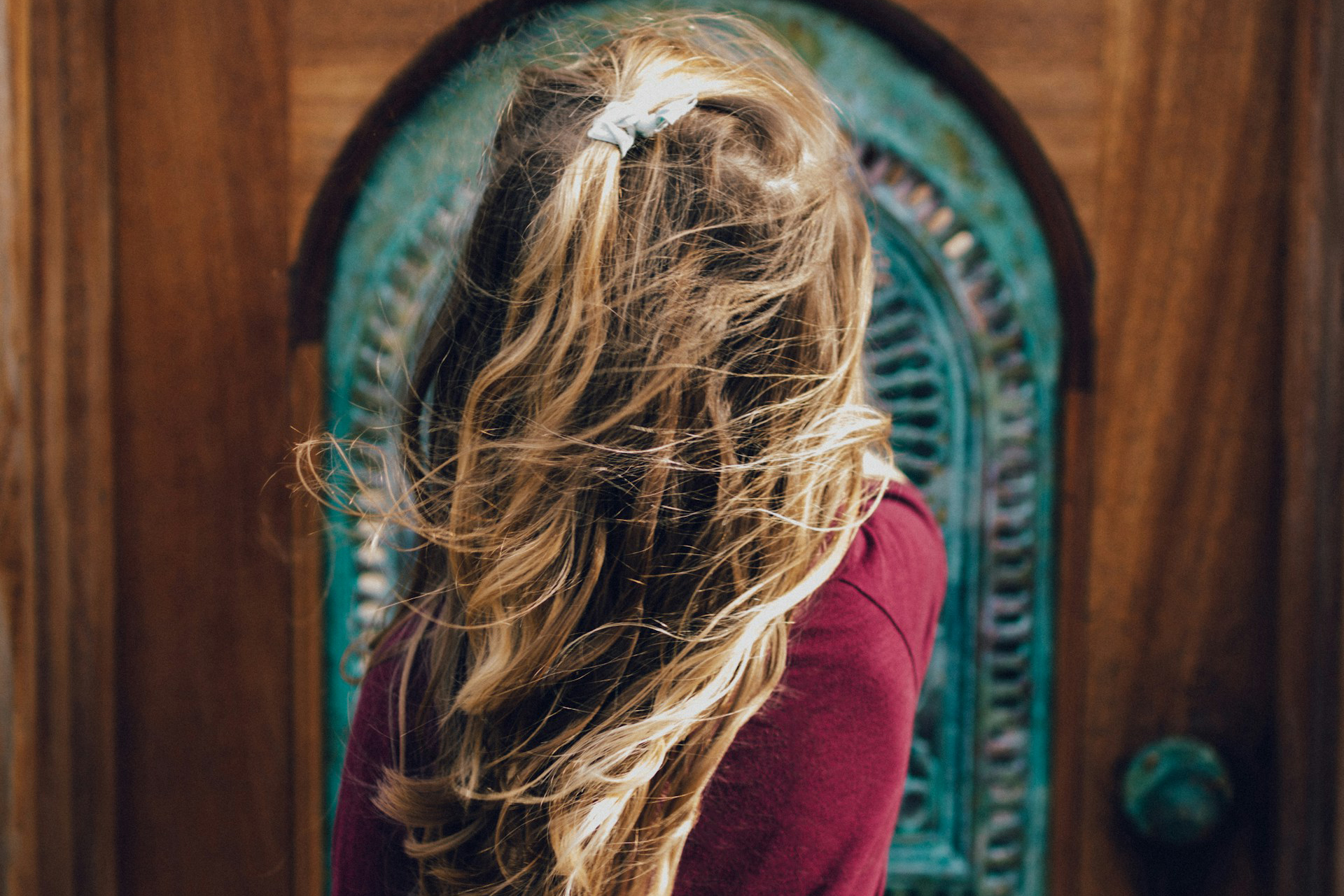 child standing outside of a closed door