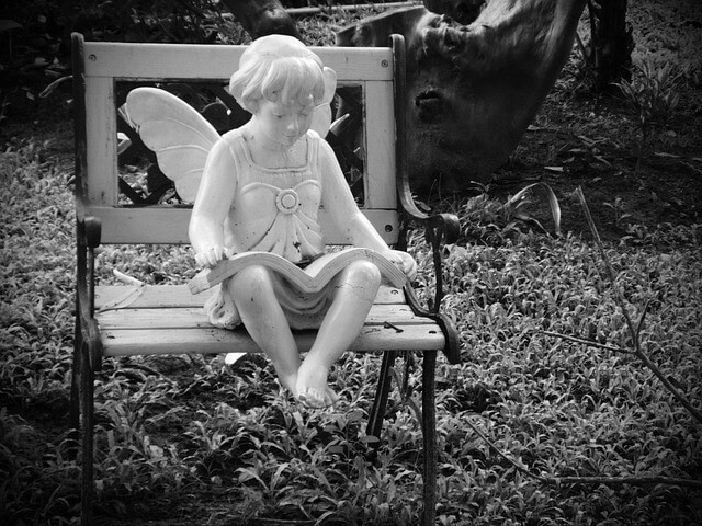 statue of angel reading Bible