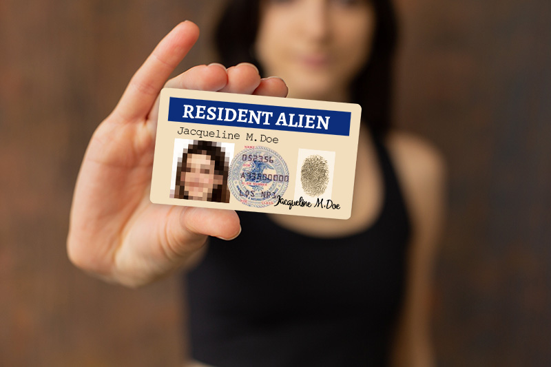 purposeful woman holding "resident alien" card