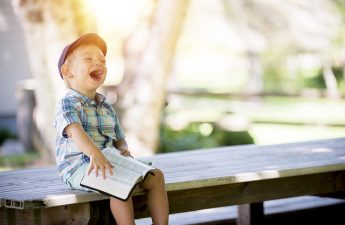 boy holding open Bible and laughing