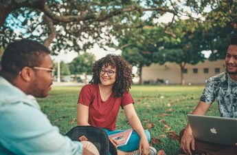 young people seated on the ground talking
