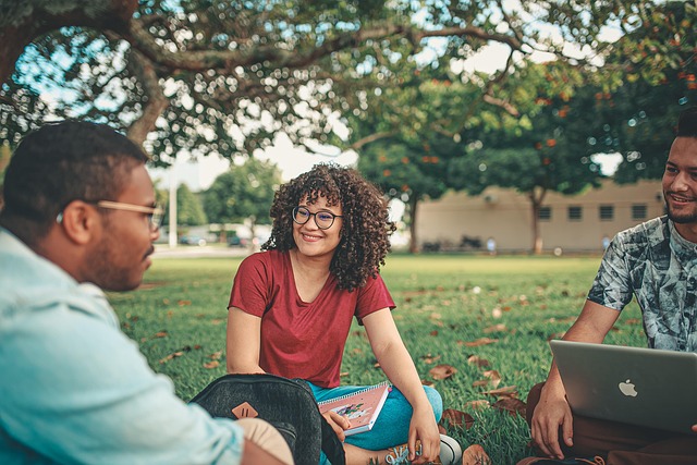 young people seated on the ground talking